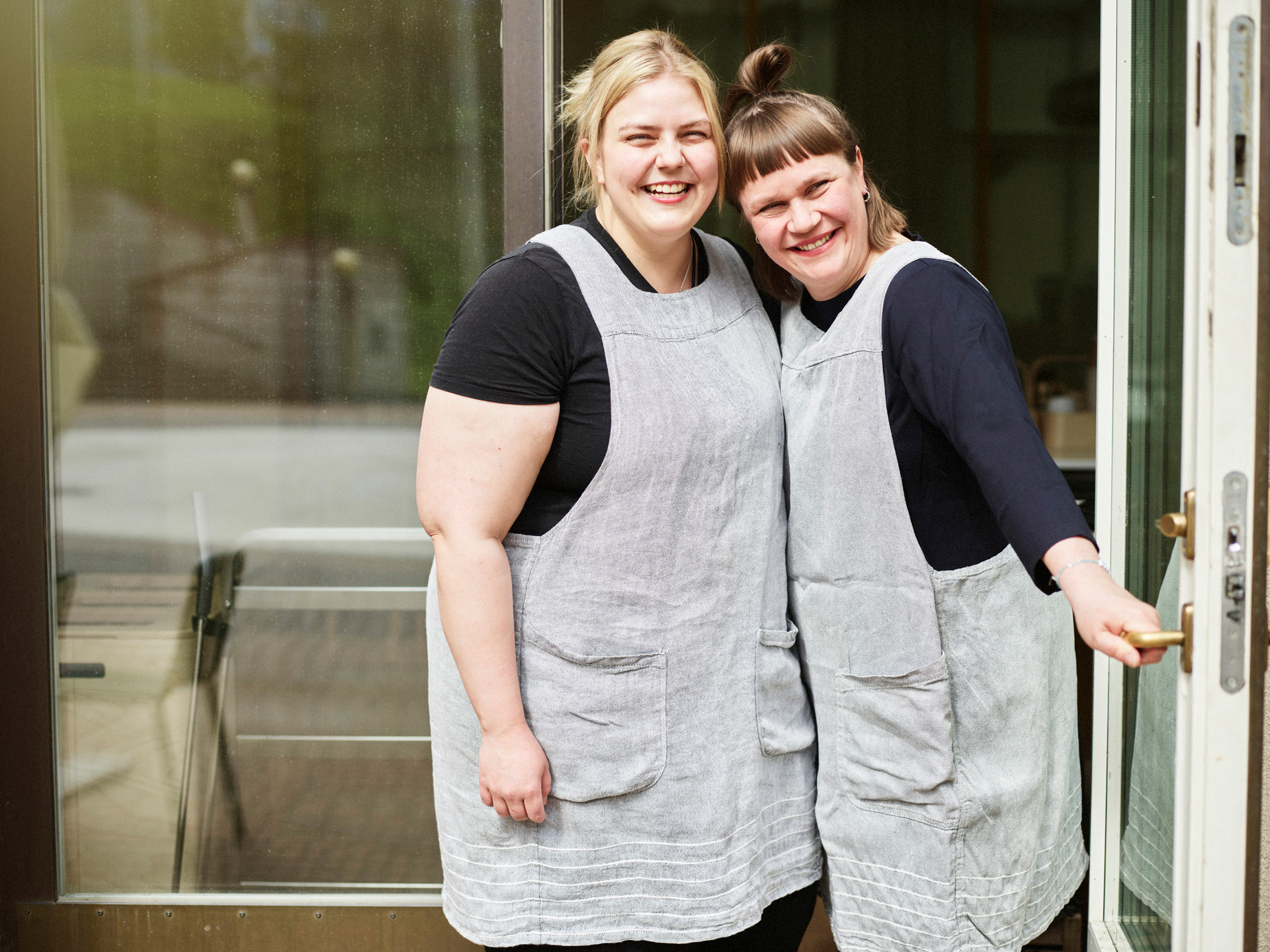 Cafén henkilökuntaa hymyilemässä aurinkoisesti.