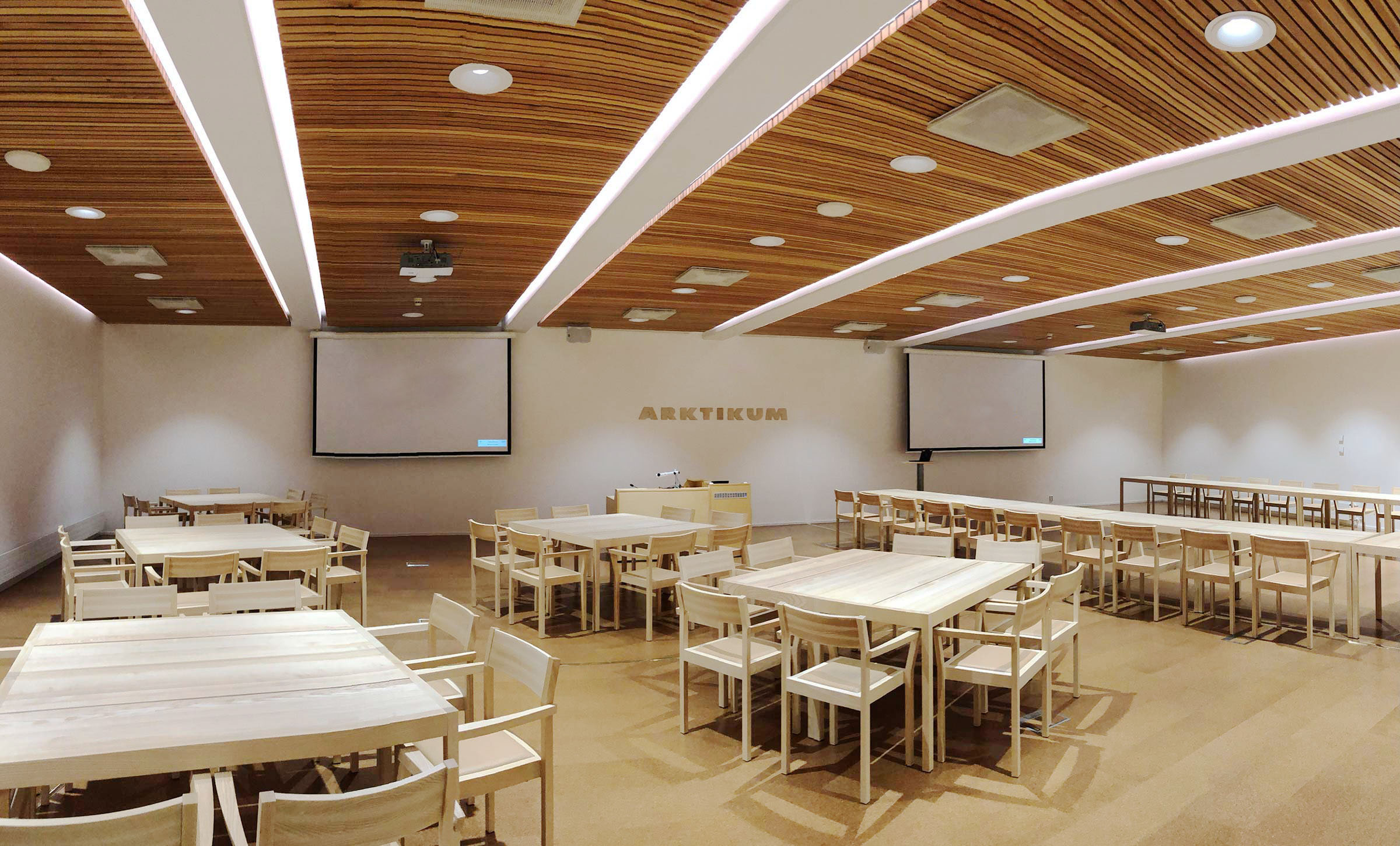 Aurora-kokoustilassa 2 näyttöä ja pöydät aseteltu ryhmittäin